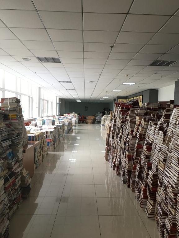 将书架上已经打包的图书按类有序摆放